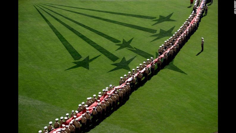 Infantes de la marina de Estados Unidos sostienen una bandera antes del himno nacional en el Juego de Estrellas de las Grandes Ligas de Béisbol el 12 de julio.