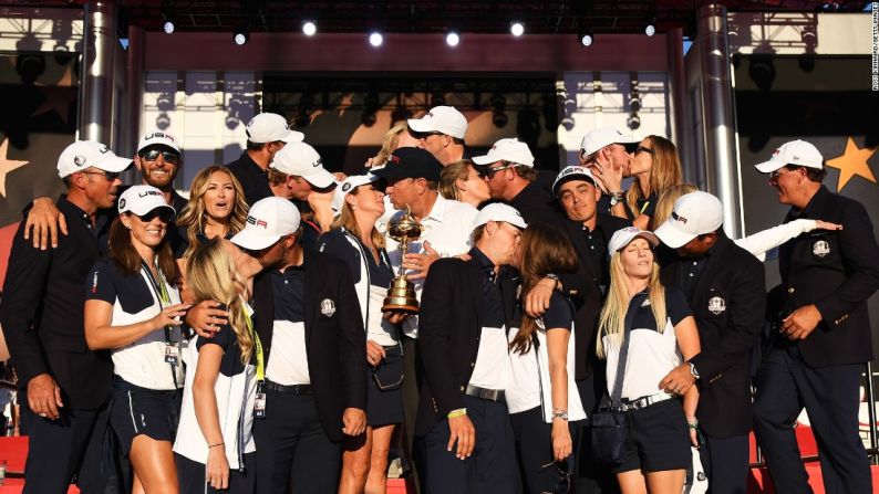 El golfista Rickie Fowler se encoge de hombros mientras sus compañeros del equipo de Estados Unidos besan a sus esposas durante una foto grupal el 2 de octubre. Los estadounidenses acababan de ganar su primera Copa Ryder desde 2008.