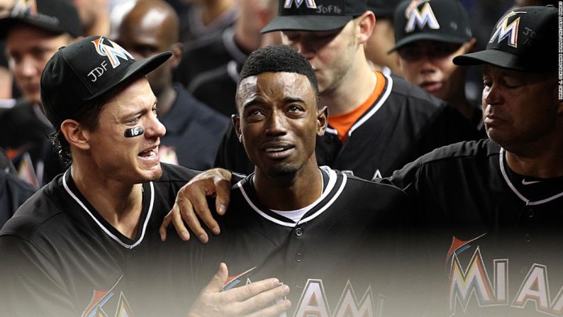 El jugador de la segunda base de los Marlins de Miami, Dee Gordon, es consolado por sus compañeros de equipo después de que arrancara el juego bateando un jonrón contra los Mets de Nueva York, el lunes 26 de septiembre. Gordon y el resto de los Marlins estaban de luto por su compañero Jose Fernández, quien murió en el día anterior durante un accidente en un barco: tenía 24 años.