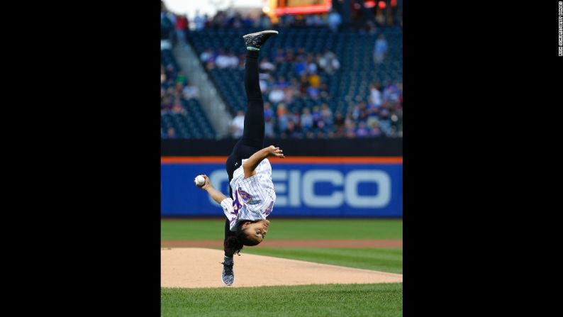 La gimnasta Laurie Hernández, ganadora una medalla olímpica de oro, se voltea en el aire mientras hace el primer lanzamiento antes de un juego de los Mets de Nueva York, el sábado 3 de septiembre.