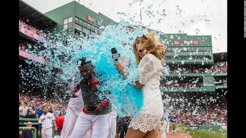 La reportera de televisión Guerin Austin parece estar en el lugar equivocado en el momento en que compañeros del beisbolista David Ortiz, de los Medias Rojas de Boston, lo mojan tras un partido el sábado 14 de mayo.