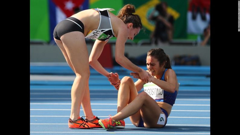 La neozelandesa Nikki Hamblin (izquierda) ayuda a la estadounidense Abbey D'Agostino (derecha) tras chocar el jueves 16 de agosto, durante la semifinal de los 5.000 metros de los Juegos Olímpicos de Río 2016.