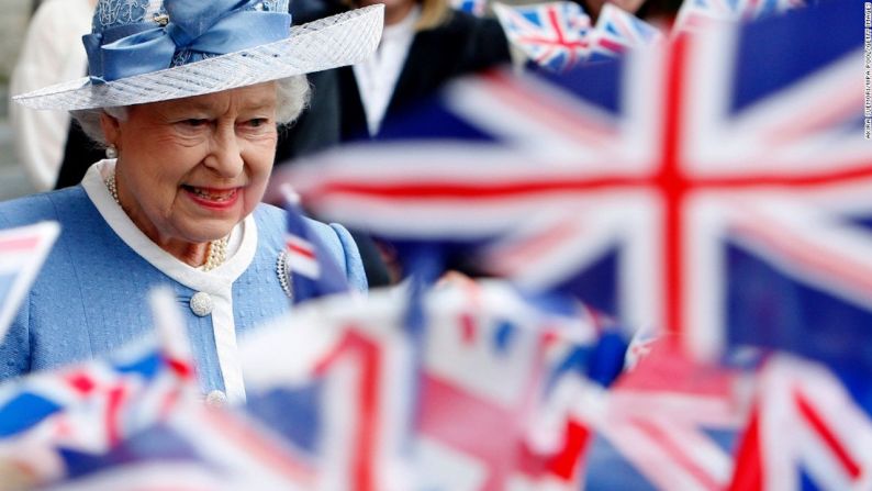 El público ondea sus banderas al paso de la reina Isabel II al salir de la Catedral de San Pablo, en Londres, durante el aniversario 300 de los servicios de esta iglesia, en junio de 2011.