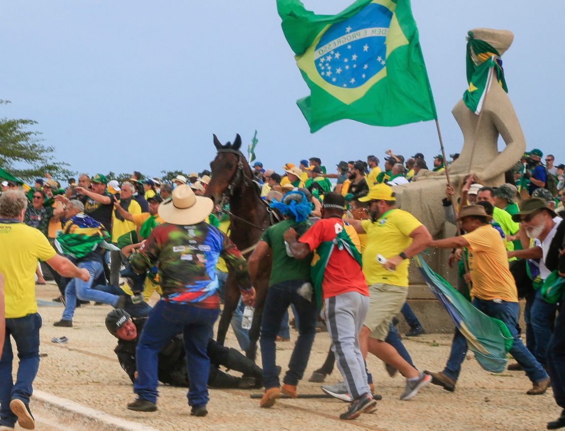 Un agente de la Policía Militar cae de su caballo durante los enfrentamientos con simpatizantes de Bolsonaro tras una invasión al Palacio Presidencial de Planalto.