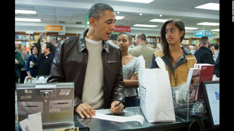 Obama, con Sasha en el centro y Malia a la derecha, paga sus compras en la librería ‘Politics & Prose’ en el noroeste de Washington en noviembre de 2013.