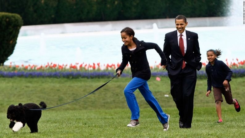 El presidente lleva a Malia, a la izquierda, y a Sasha a que saquen a pasear a su nuevo perro Bo, en el jardín sur de la Casa Blanca en abril de 2009. El perro de aguas portugués fue un regalo del senador Edward Kennedy. La primera familia eligió al cachorro de raza pura sobre todo por las alergias de Malia.