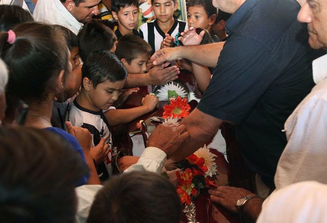 Un grupo de niños le dicen adiós al ídolo paraguayo Roberto Cabañas en su natal Pilar.