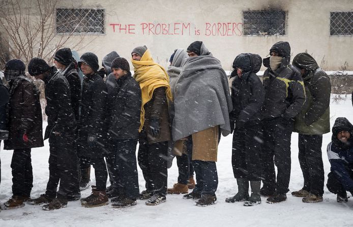 En la fila, los refugiados esperan para obtener su ración de comida.