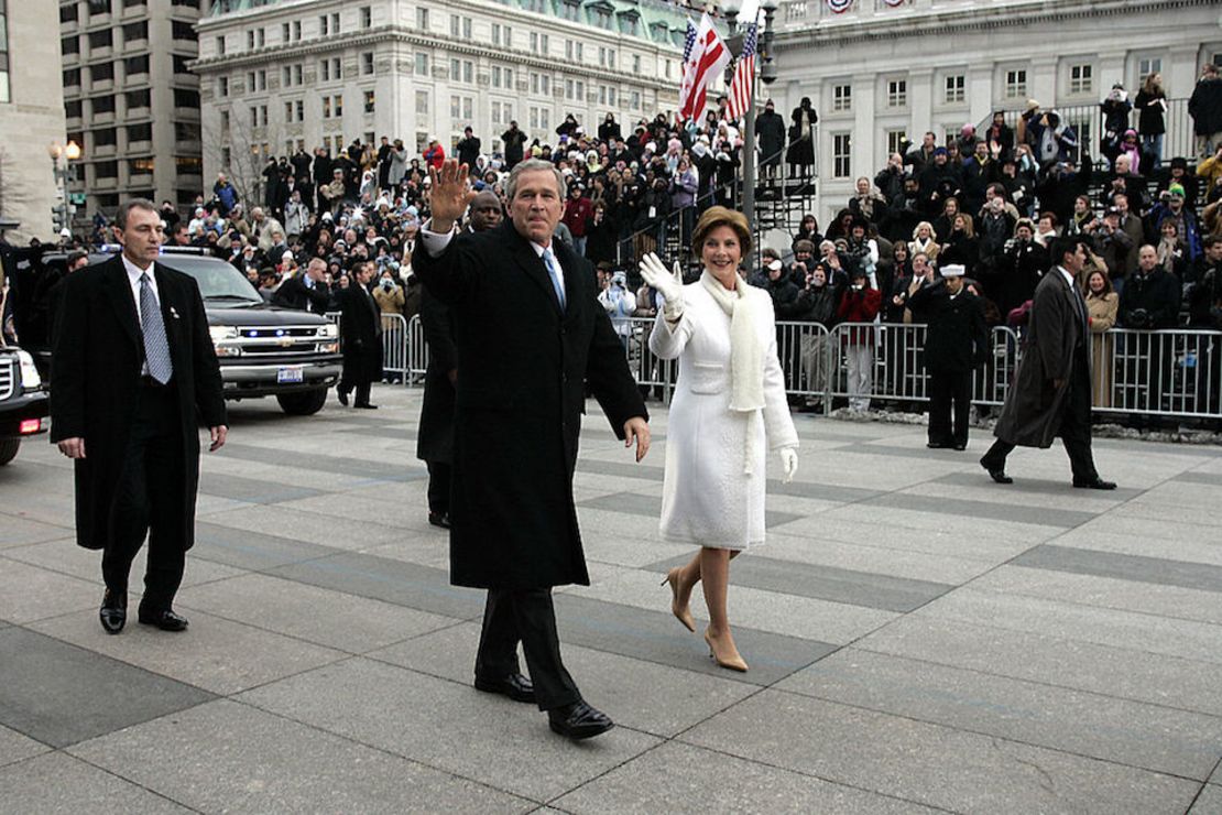 WASHINGTON, UNITED STATES:  US President George W. Bush (L) waves to a cold crowd while walking down Pennsylvania Avenue with First Lady Laura Bush during the Inaugural Parade 20 January 2005 in Washington, DC. Bush launched his second term with an urgent pledge to spread freedom to 'the darkest corners of our world' and vowed to heal divisions. including those over the war in Iraq. AFP PHOTO/POOL/DOUG MILLS