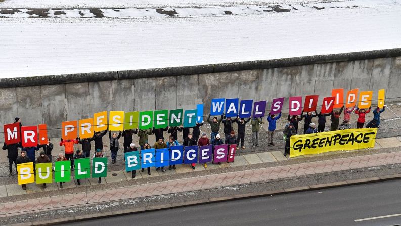 "Señor presidente los muros dividen. ¡Construya puentes!", reza un mensaje de activistas de Greenpeace para Donald Trump junto al muro de Berlín en Alemania.