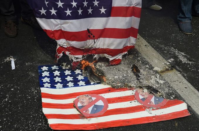 Manifestantes en Manila quemaron una bandera simulada de Estados Unidos (abajo) con la foto de Donald Trump durante una marcha frente a la embajada de Estados Unidos antes de la toma de posesión de Trump.