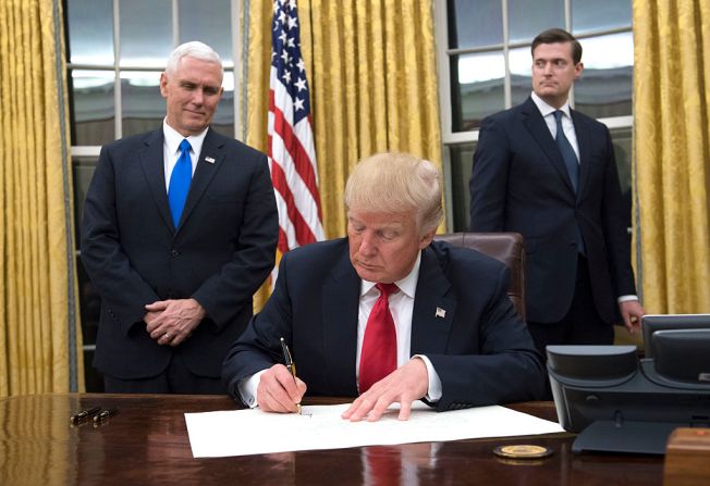 El presidente Donald Trump firma la confirmación de James Mattis como su secretario de Defensa en la Oficina Oval, durante la noche de su inauguración.