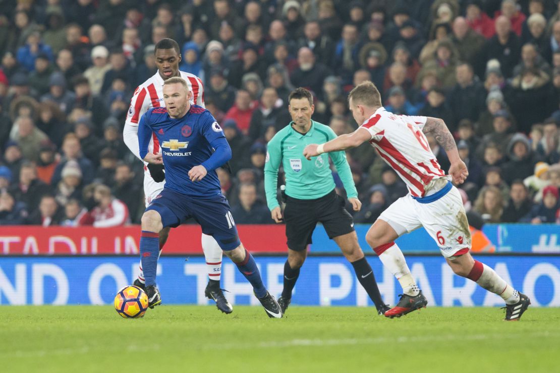 Wayne Rooney (i) disputa el balón con Glenn Whelan, del Stoke City, durante el partido de la Liga Premier del sábado pasado en Stoke-On-Trent.