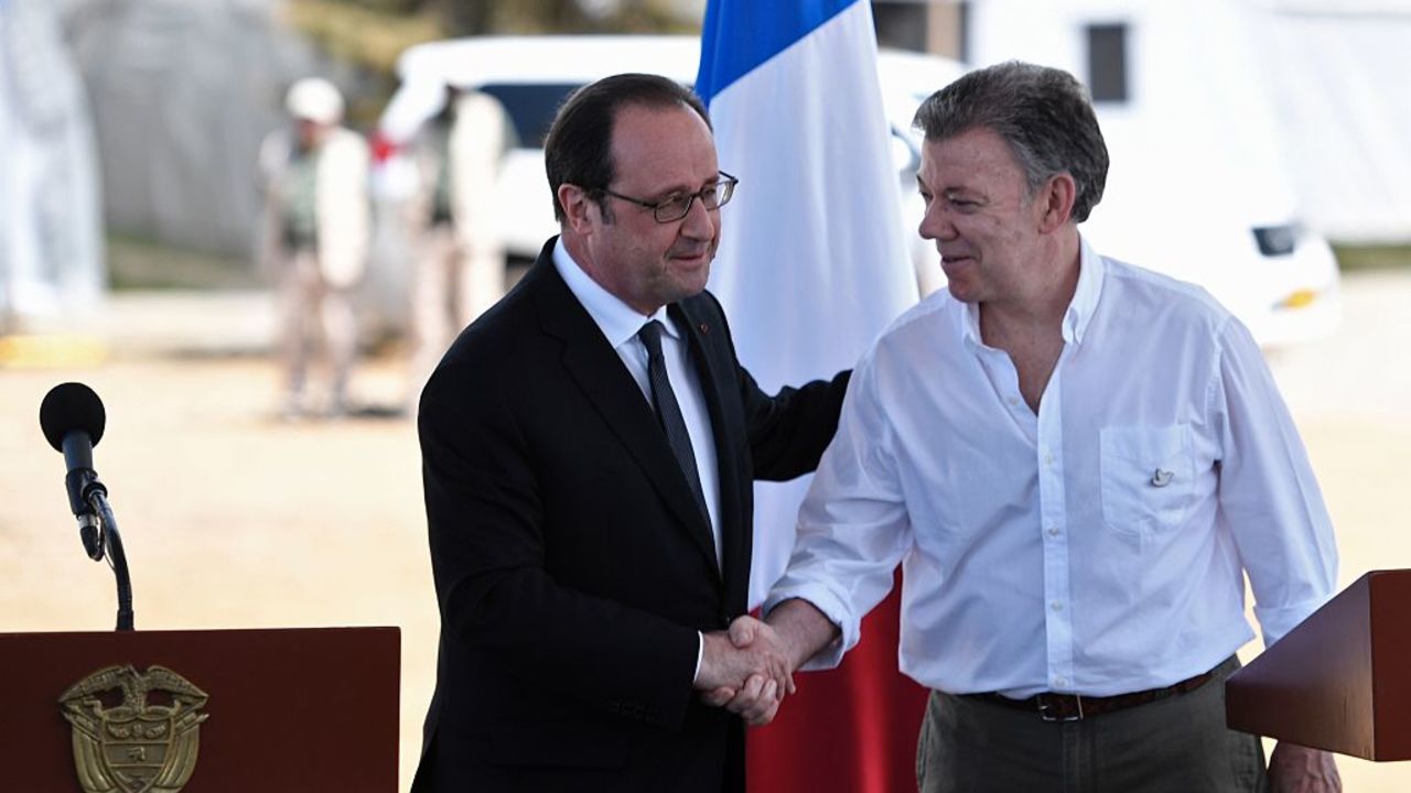 Colombian President Juan Manuel Santos (R) and French President Francois Hollande shake hands after delivering a joint press conference in Caldono, Valle del cauca department, Colombia on January 24, 2017, during a visit to a FARC rebel disarmament zone. 
Hollande is on a Latin American tour to Chile and Colombia -- one of his last foreign trips before stepping down after April-May elections choose his successor / AFP / STEPHANE DE SAKUTIN