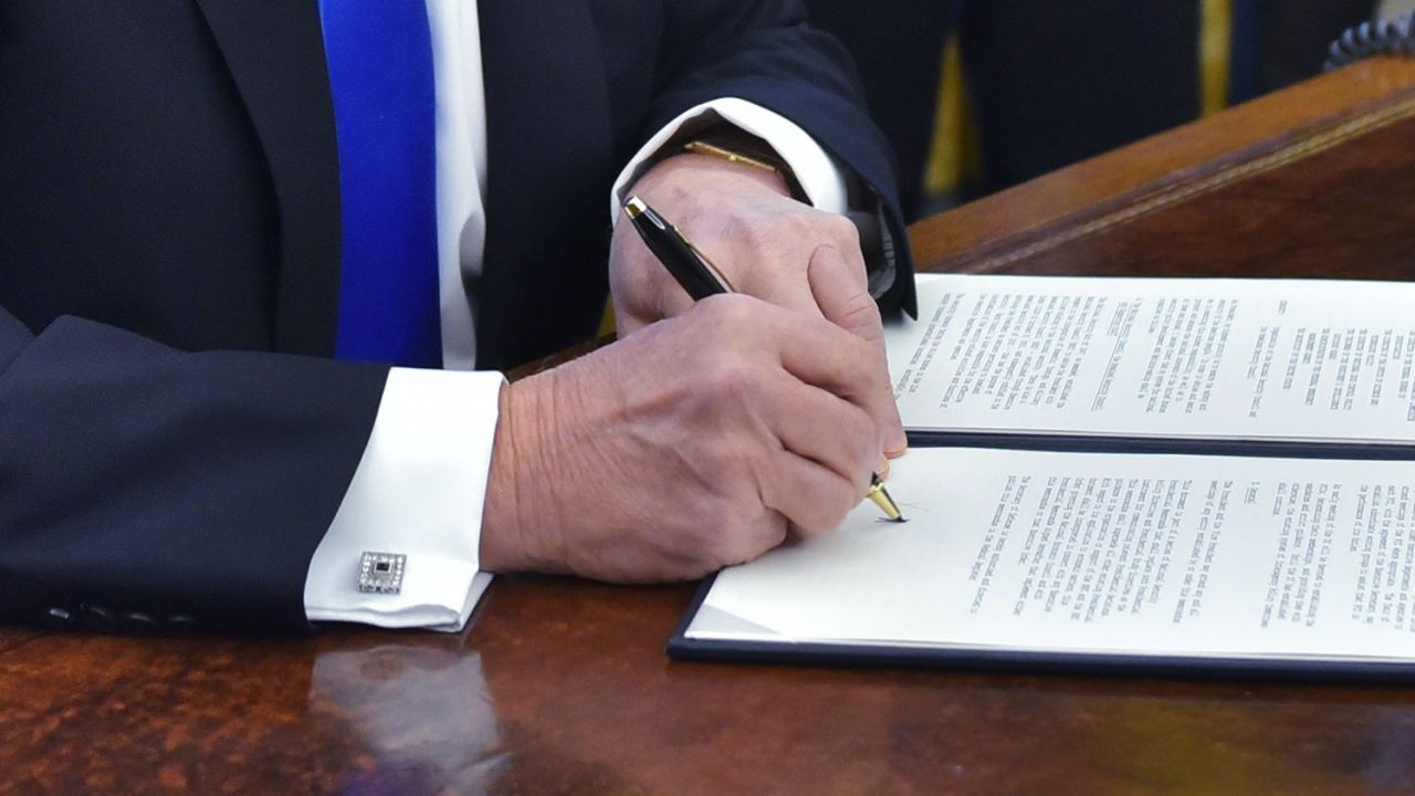 US President Donald Trump signs an executive memorandum on defeating the Islamic State in Iraq and Syria after signing it in the Oval Office of the White House on January 28, 2017, in Washington, DC. / AFP / MANDEL NGAN