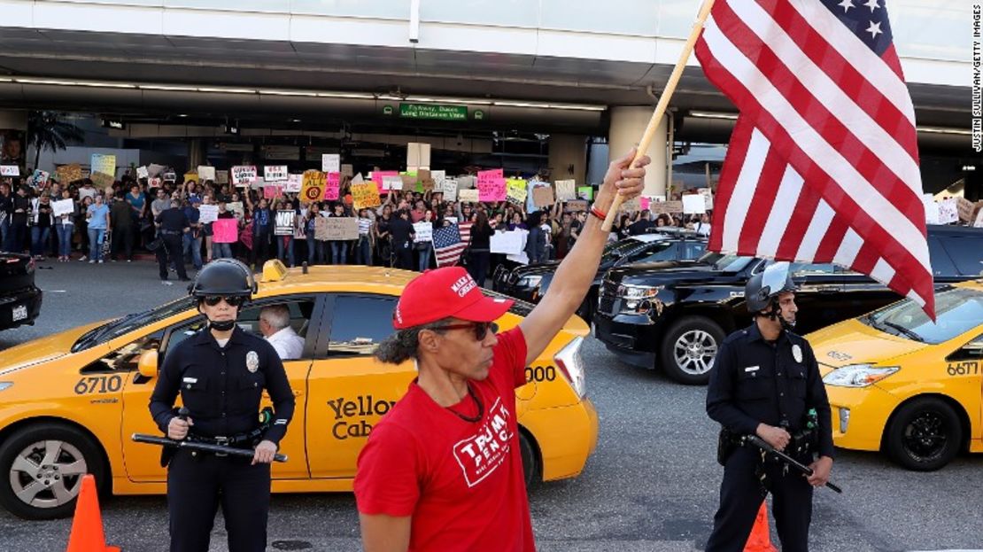 Un partidario del presidente Trump agita una bandera de Estados Unidos en el aeropuerto internacional de Los Ángeles este domingo, durante una demostración sobre la prohibición inmigratoria.