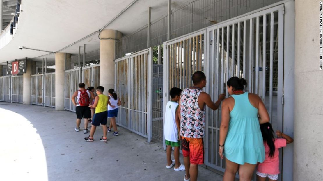 Turistas miran a través de las entradas principales del estadio.