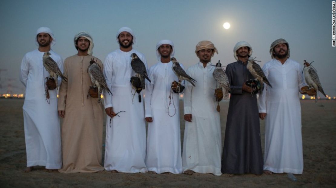 Hombres emiratíes posan con sus halcones tras una sesión de entrenamiento.