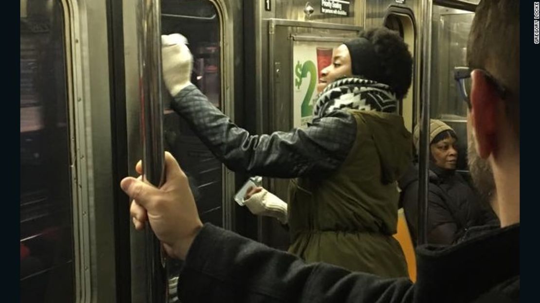 Una pasajera ayuda a remover el graffiti del tren.