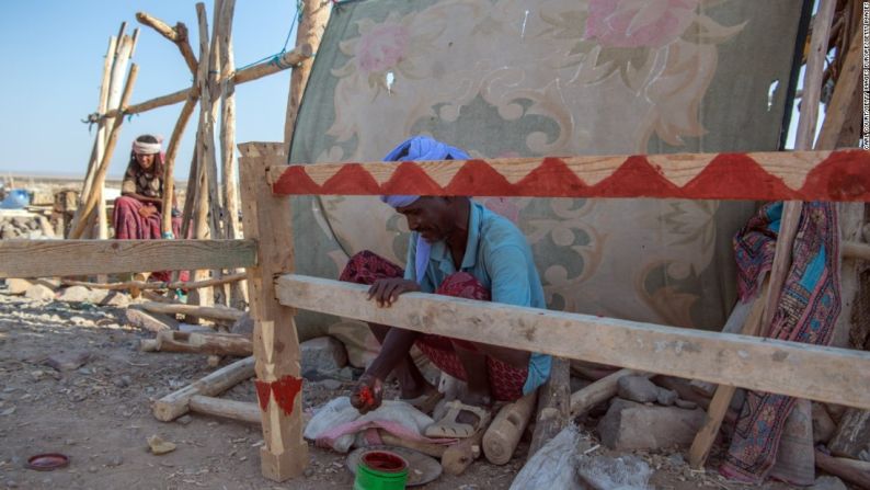 Durmiendo en el lugar — Un hombre decora el marco de una cama que construyó recientemente en la depresión. Esto le permitirá estar cerca del lugar.