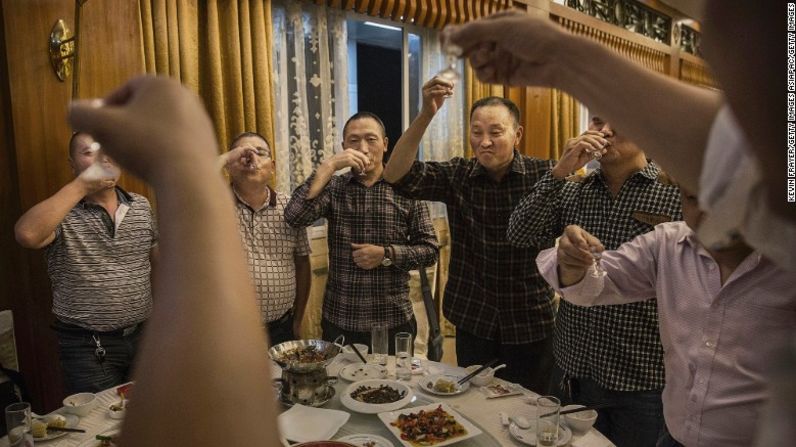 Hombres chinos brindan con tragos de Moutai, la marca más famosa de baijiu, un licor muy fuerte destilado de sorgo y de arroz que en China se bebe en cualquier ocasión festiva, desde un matrimonio hasta una reunión de negocios.