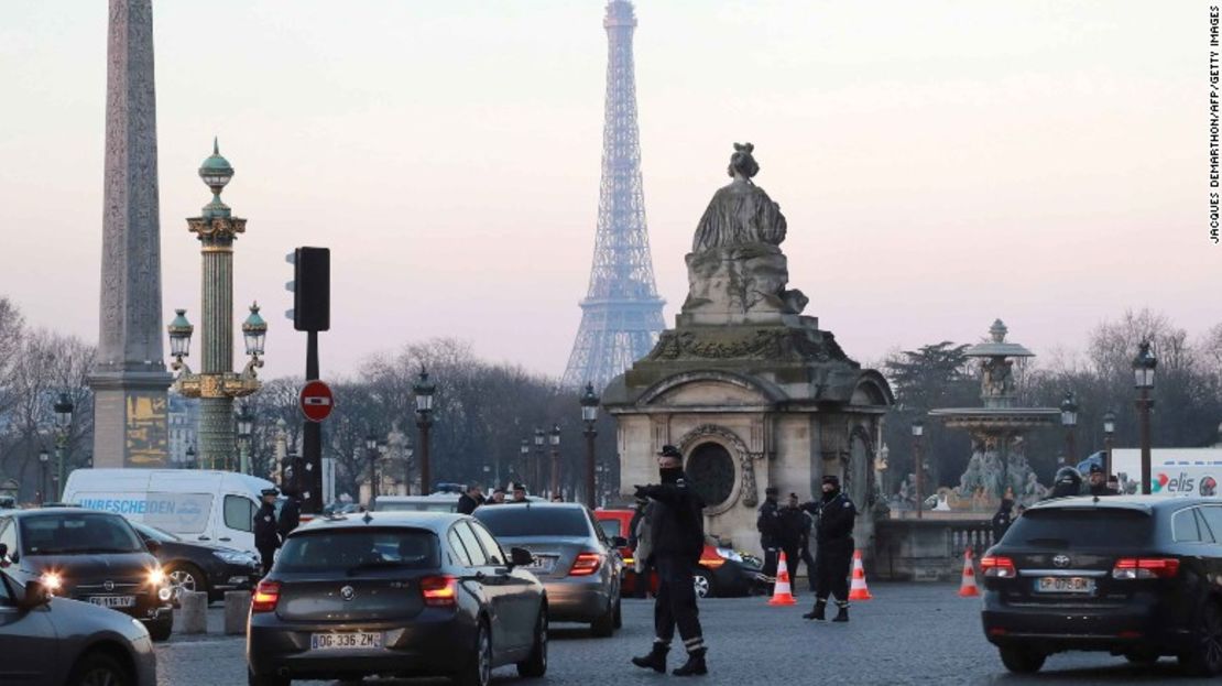 Un policía regula el tráfico en París, donde las restricciones al tráfico vehicular buscan ponerle un freno a la contaminación.