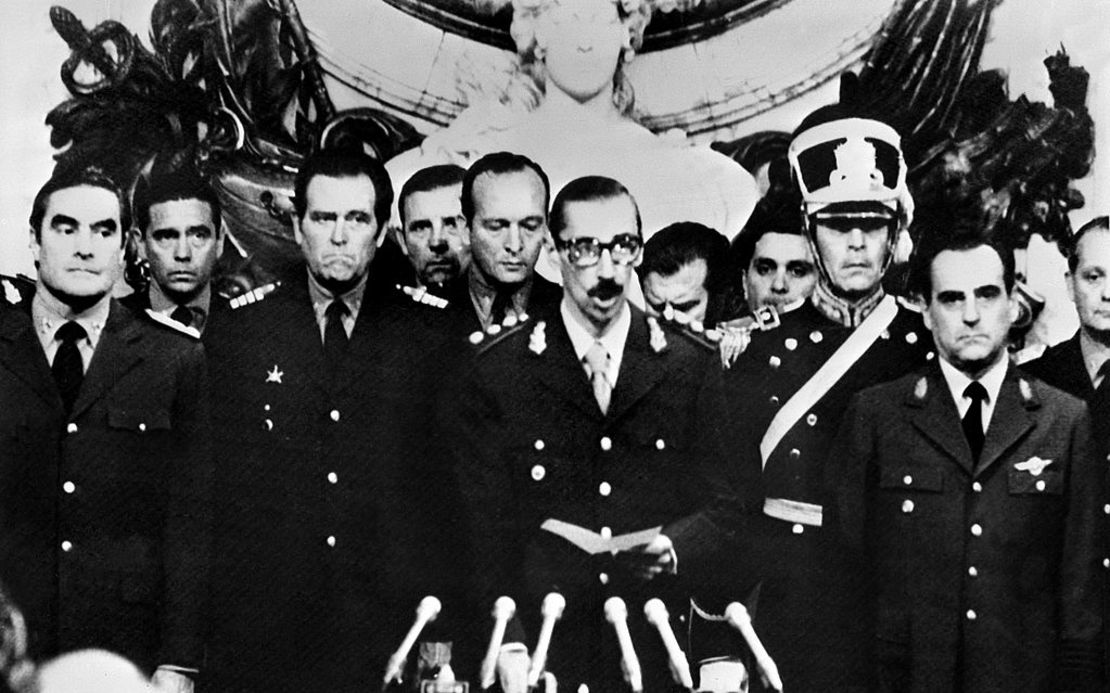 Fotografía tomada en Buenos Aires, el 29 de marzo de 1976 del general Jorge Rafael Videla (C) en momentos en que jura como presidente de la Argentina, luego del golpe de Estado militar del 24 de marzo de 1976. A la izquierda esta el almirante Eduardo Emilio Massera y a la derecha el brigadier Orlando Ramón Agosti.