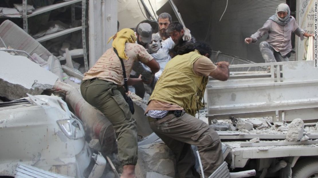 Voluntarios sirios rescatan de los escombros a un sobreviviente después de fuertes bombardeos en la ciudad de Idlib.