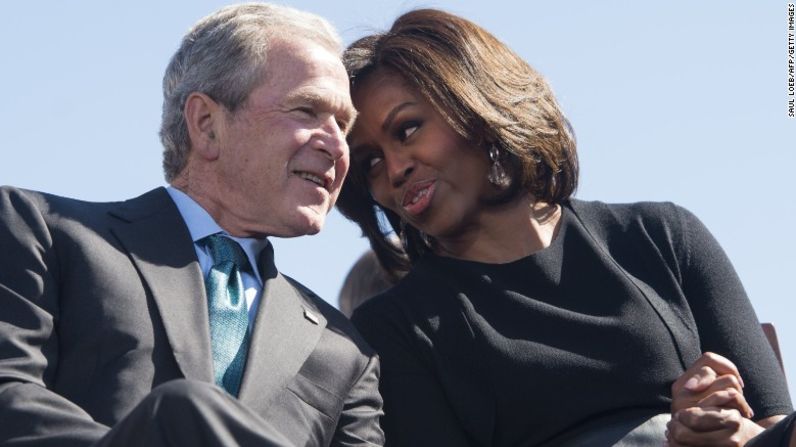 El expresidente George W. Bush habla con la primera dama Michelle Obama, durante un evento que marca el aniversario número 50 de las marchas de derechos civiles en el puente Edmund Pettus en Selma, Alabama, el 7 de marzo de 2015.