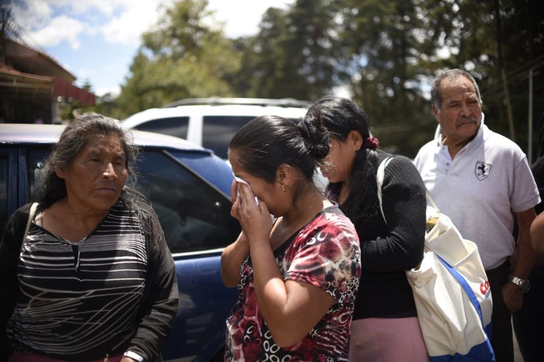 Familiares de los menores lloran a las afueras del centro de rehabilitación de Guatemala esperando noticias tras el incendio.