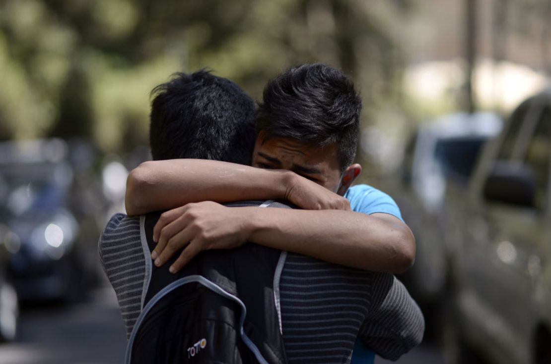 Un sobreviviente del incendio del centro de rehabilitación de Guatemala se abraza con un familiar.