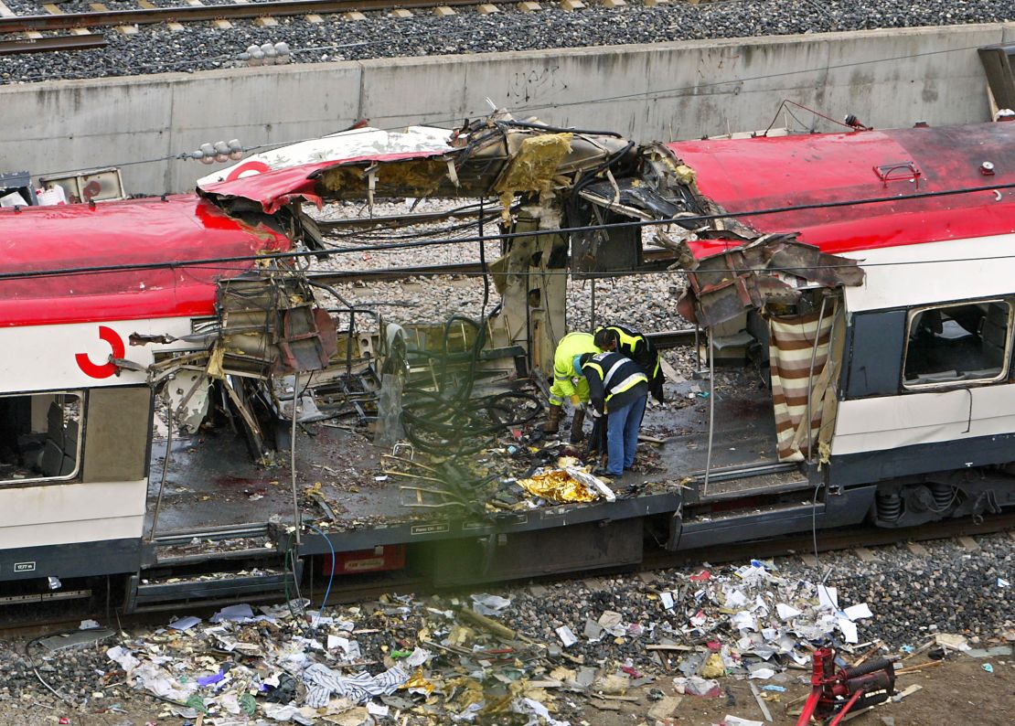 Expertos forenses inspeccionan los trenes que explotaron en la estación de tren de Atocha el día anterior, 12 de marzo de 2004 en Madrid.