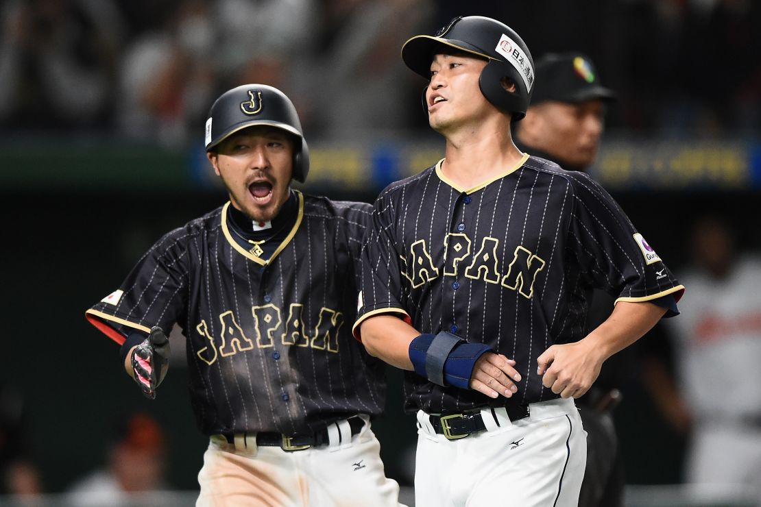 Los japoneses Ryosuke Kikuchi (i) y Norichika Aoki (d) celebran tras anotarle una carrera a Holanda durante el partido de la serie E en Tokio.