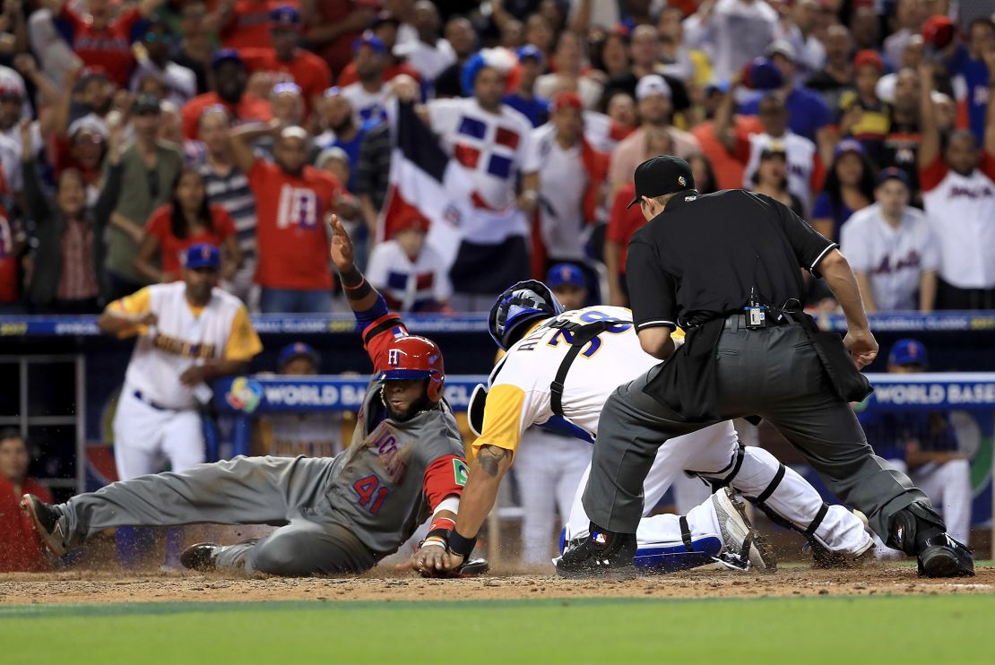 Carlos Santana, de República Dominicana, se desliza para anotar una carrera ante el esfuerzo del colombiano Jorge Alfaro durante su partido del grupo C en Miami.