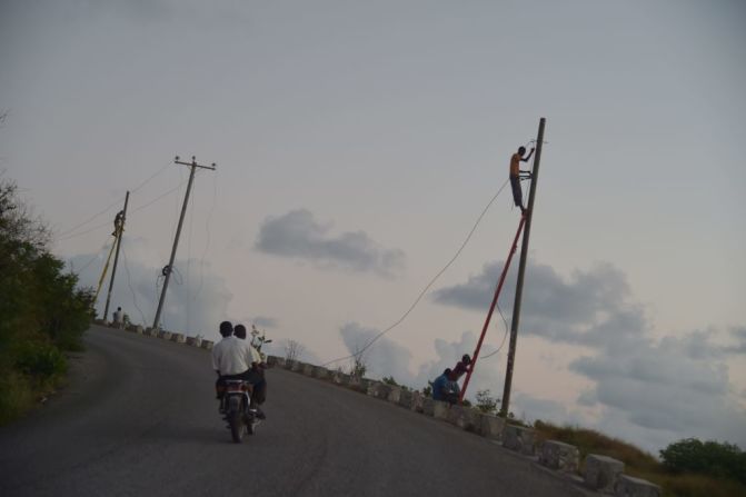 Un grupo de hombres repara una línea telefónica que resultó dañada por Matthew, en octubre pasado. Naciones Unidas calcula que el paso del huracán por el país más pobre de América dejó más de 570 muertos y unas 750.000 personas “seriamente afectadas”.