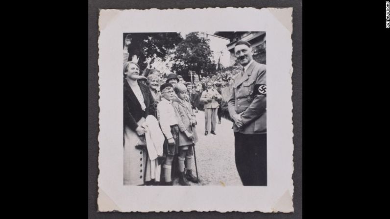 Hitler posa junto a unos niños sonrientes.