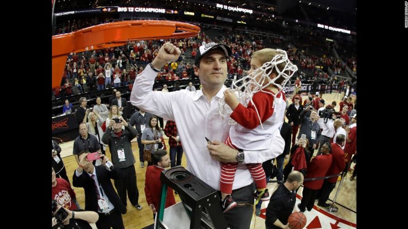 El entrenador de Iowa State, Steve Prohm, sostiene a su hija de 2 años, Cass, mientras corta la red del Torneo Big 12 el sábado 11 de marzo. Iowa State le ganó por 80-74 a West Virginia en la final.