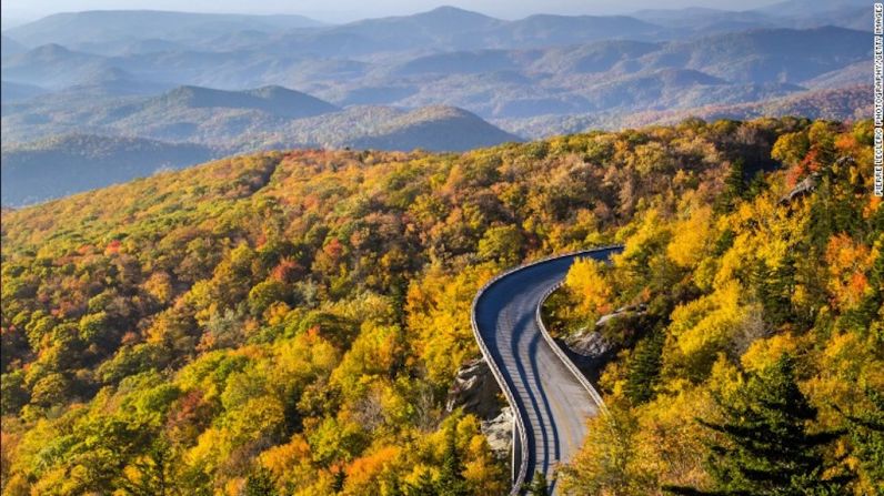 Blue Ridge Parkway, Carolina del Norte/Virginia: La vía Blue Ridge serpentea por 754 kilómetros entre dos estados, revelando increíbles vistas de las zonas montañosas de los Apalaches que varían increíblemente cada temporada. El follaje cambiante del otoño se evidencia en una vista del amanecer del Viaducto Linn Cove en la milla 304 de Carolina del Norte.