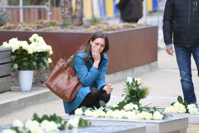 Una mujer rinde tributo cerca del monumento a las víctimas ubicado en las instituciones de la Unión Europea.