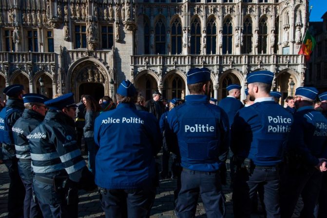 Un grupo de policías reunidos en la Grand Place de Bruselas rinde tributo a las víctimas.