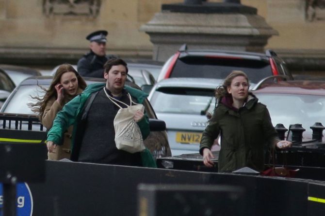 Un grupo de personas corre mientras es evacuada de las Casas del Parlamento en el corazón de Londres tras un incidente en el Parlamento británico.