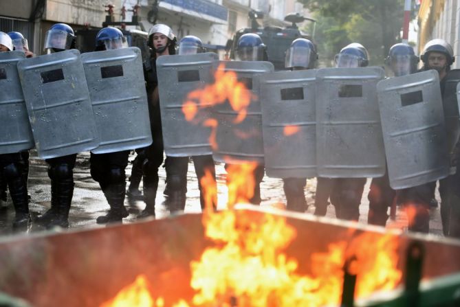 Policía de disturbios sostienen sus escudos para contener las protestas que esta viernes tienen lugar en Paraguay tras la aprobación de una enmienda constitucional para la reelección presidencial.