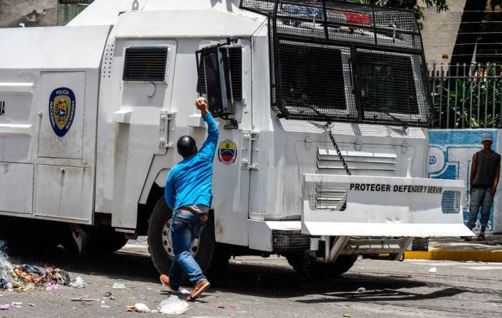 Un manifestante golpea con una piedra con un camión blindado de la Guardia Bolivariana durante las protestas de este martes.