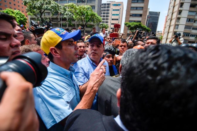 El líder opositor y gobernador del estado Miranda, Henrique Capriles y el presidente de la Asamblea Nacional, Julio Borges, les hablan a los policías antimotines durante la protesta contra el gobierno del presidente Nicolás Maduro este 4 de abril.