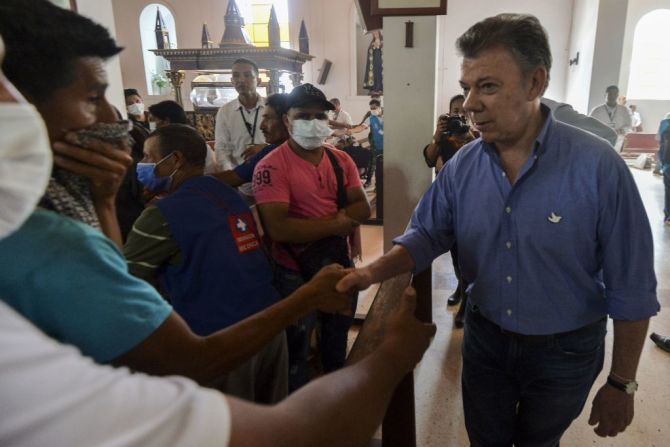 El presidente de Colombia Juan Manuel Santos saluda a los familiares de una de las víctimas que dejó la avalancha de lodo y piedras que destruyó varios barrios de la capital del departamento de Putumayo. (LUIS ROBAYO/AFP/Getty Images).