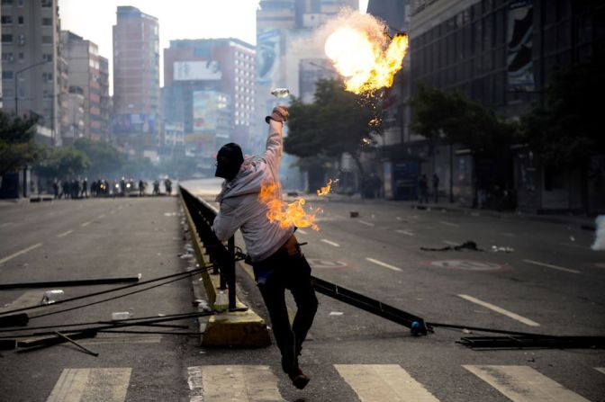 Un manifestante lanza un objeto encendido durante las protestas.