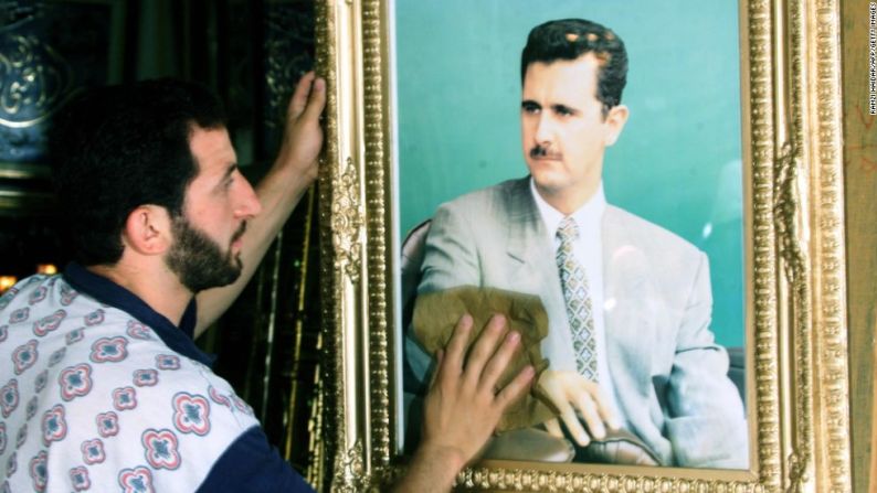 Un comerciante limpia una foto de al Assad en Damasco, el 20 de junio del 2000, días antes del histórico Congreso del Partido Baath, en el que al Assad fue consagrado como secretario general del mismo.