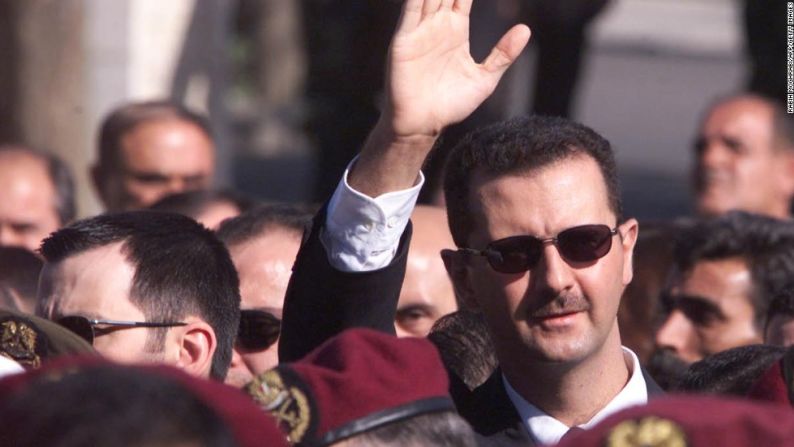 Al Assad saluda a algunos seguidores mientras camina detrás del ataúd de su padre, durante el funeral que se llevó a cabo el 13 de junio del 2000 en Damasco.