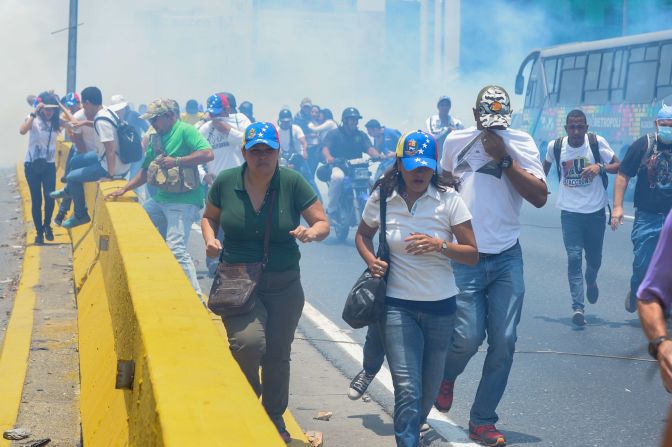 Manifestantes huyen luego que la GNB lanzara un gas de color azul para dispersar la concentración.