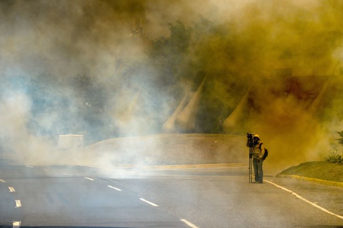 Un periodista en medio de una nube de gas lacrimógeno.